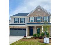 Two-story home features a brick facade, gray siding, a two-car garage, and a well-manicured lawn at 13748 Roderick Dr # 174, Huntersville, NC 28078