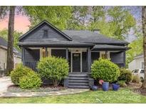 Charming front exterior showcasing a dark painted home with a welcoming front porch and manicured landscaping at 1824 Umstead St, Charlotte, NC 28205