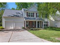 Charming two-story home with a well-manicured lawn, a two-car garage, and red window shutters at 2856 Huckleberry Hill Dr, Fort Mill, SC 29715