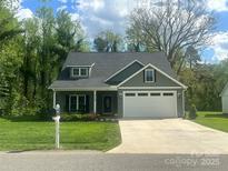 Charming home featuring a two-car garage, well-manicured lawn, and a welcoming front porch perfect for relaxing at 3128 Harmon Homestead Rd, Shelby, NC 28150