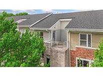 Exterior view of the home with neutral siding, brick accents, and a private balcony at 534 Donatello Ave, Charlotte, NC 28205