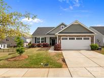 Charming home features a two-car garage, manicured lawn, and attractive stone accents for enhanced curb appeal at 550 Cherry Blossom Nw Ave, Concord, NC 28027