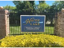 Harris Lake Privately Owned Condominiums community entrance sign with black metal fence, brick columns, and manicured lawn at 5810 Harris Grove Ln, Charlotte, NC 28212