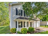 Charming two-story home featuring a well-maintained yard and inviting front porch with black accents and white trim at 9419 Isaac Hunter Dr, Charlotte, NC 28214