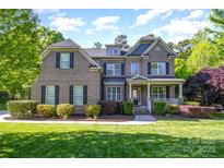 Stunning brick home with lush landscaping and a welcoming front porch at 10328 Lemington Dr, Mint Hill, NC 28227