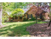 Charming brick home with lush green lawn and mature trees providing shade and curb appeal at 1058 General Hoke Dr, Lincolnton, NC 28092