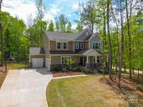 Charming two-story home featuring a two-car garage, inviting front porch and a basketball court at 11215 Dappled Light Trl, Charlotte, NC 28227