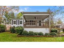Charming home with a covered porch, dark shutters, and landscaped yard at 132 Larboard Trl, Mount Gilead, NC 27306