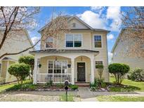 Charming two-story home with a welcoming front porch and beautifully landscaped front yard at 13610 Aldenbrook Dr, Huntersville, NC 28078