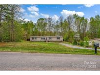 Charming single-story home with a well-maintained lawn and surrounded by lush trees at 151 Brown Farms Dr, Cleveland, NC 27013