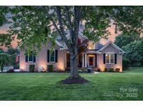 Charming brick home featuring a well-manicured lawn, a red door, and traditional black shutters at 1614 Crestgate Dr, Waxhaw, NC 28173
