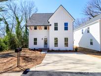Beautiful two-story home featuring white siding, a dark roof, and a well-maintained front yard at 2501 Elon St, Charlotte, NC 28208