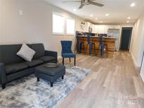 Open-concept living room featuring modern vinyl flooring, stylish furniture, and natural light at 109 W Poplar St, Stanley, NC 28164
