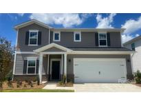 Charming two-story home featuring gray siding, black shutters, and a two-car garage at 115 Vaquaro Dr, Mooresville, NC 28115