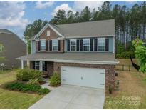 Charming brick and blue two-story home with a two-car garage and manicured front lawn at 127 Slip Shot Ln, Troutman, NC 28166