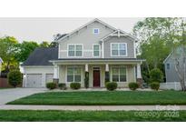 Charming two-story home with a well-manicured lawn and inviting front porch at 5808 Mcdowell Run Dr, Huntersville, NC 28078