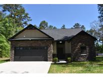 Charming single-story home featuring stone accents, a dark gray roof, and a two-car garage at 6519 Pargo Rd, Charlotte, NC 28216