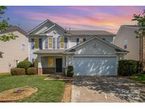 Charming two-story home with a well-manicured lawn and attached two-car garage with neutral siding at 6618 Latherton Ln, Charlotte, NC 28278