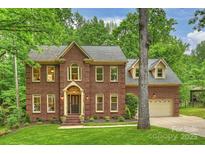 Charming two-story brick home with a well-manicured lawn and mature trees at 7067 Rocky Falls Rd, Charlotte, NC 28211