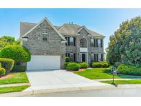 Charming gray brick two-story home with a well-manicured lawn, mature trees, and a two car garage at 709 Circle Trace Rd, Monroe, NC 28110