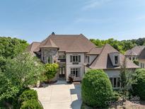 Elegant home with a combination of stone and stucco, complemented by mature landscaping and a circular driveway at 7409 Stonecroft Park Dr, Charlotte, NC 28226