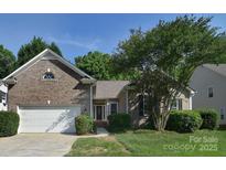 Charming brick home with a well-manicured lawn and attached two-car garage at 2415 Tory Oak Pl, Matthews, NC 28105