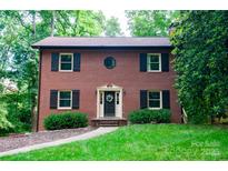 Charming two-story brick home with black shutters and lush green landscaping at 2540 Heritage Cir, Statesville, NC 28625