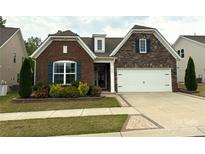 Charming home featuring a brick and stone facade, well-manicured landscaping, and an attached two-car garage at 3028 Quinebaug Rd, Fort Mill, SC 29715