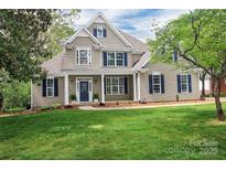 Inviting two-story home boasts a lush lawn, mature trees, and beautiful landscaping at 312 Peach St, Shelby, NC 28150