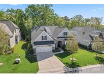 Aerial view of home highlighting its manicured lawn, three-car garage, and stone detailing at 4012 Brandywine Ter, Lancaster, SC 29720