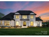Stunning two-story home with a manicured lawn and elegant architectural details, illuminated at twilight at 405 Sugar Maple Ln # 41, Weddington, NC 28104