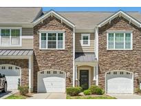 Charming townhome featuring a stone facade, attached garage, and inviting entryway at 4648 Craigmoss Ln, Charlotte, NC 28278