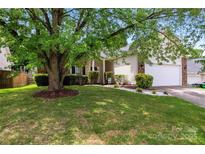 Charming home featuring a well-manicured front yard, lush landscaping, and a welcoming two-car garage at 5927 Patricia Ryan Dr, Charlotte, NC 28216