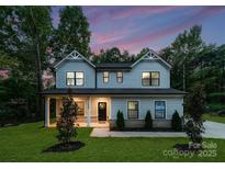 Charming two-story home featuring a landscaped yard, large windows, and a welcoming entrance at 6524 Robert St, Huntersville, NC 28078