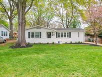 Charming, freshly painted white brick home with black shutters and lush green lawn at 901 Burnley Rd, Charlotte, NC 28210