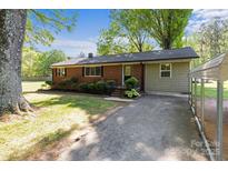 Charming single-story brick home with a well-maintained yard and a carport, creating a welcoming curb appeal at 1230 Shearers Rd, Mooresville, NC 28115