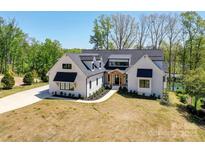 Stunning modern farmhouse featuring black window frames, black awnings and meticulous landscaping at 153 High Hills Dr, Mooresville, NC 28117