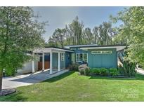 Inviting turquoise home features a well-manicured lawn and a covered carport at 1900 Lakedell Dr, Charlotte, NC 28215