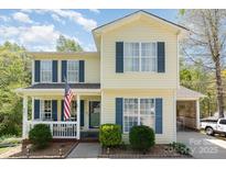 Charming two-story home with a welcoming front porch and beautiful, lush landscaping at 201 Olde Coach Ln, Crouse, NC 28033