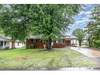 Charming one-story brick home featuring a well-maintained yard and mature shade tree at 2218 W Fifth Ave, Gastonia, NC 28052