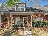 Charming brick home features a covered entryway with hanging flower baskets and a well-maintained front yard at 2731 Meadow Knoll Dr, Charlotte, NC 28269