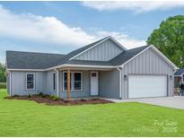 Charming single-story home features a gray exterior, a well-maintained lawn, and an attached garage at 28655-A Nc Hwy 73 Hwy, Albemarle, NC 28001