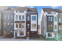 Modern townhome featuring a sleek brick and siding exterior with large windows and a pop of color from the front door at 433 Blairhill Rd # 08, Charlotte, NC 28217