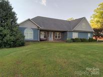 Charming single-story home with blue siding, stone accents, mature landscaping, and a spacious front yard at 4330 Goodman Lake Rd, Salisbury, NC 28146