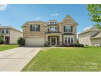 Charming two-story brick home with a well-manicured lawn and attached two-car garage at 5037 Nighthawk Dr, Fort Mill, SC 29707