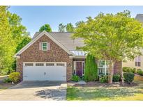 Charming brick home featuring a two-car garage, landscaped yard, and a welcoming entrance with decorative shutters at 5050 Kinross Ln, Indian Land, SC 29707