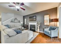 Comfortable living room featuring a fireplace, ceiling fan, and stylish decor at 5050 Kinross Ln, Indian Land, SC 29707