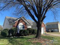 Charming brick and vinyl home with lush landscaping and mature trees in a well-maintained neighborhood at 12031 Brownestone View Dr, Charlotte, NC 28269