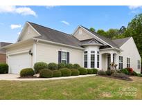 Charming home featuring a well-manicured lawn, attached two-car garage, and inviting architectural details at 1488 River Bend Blvd, Fort Mill, SC 29707