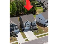 Inviting two-story home with a well-manicured lawn and a long driveway leading to an attached two-car garage at 184 Tetcott St, Mooresville, NC 28115